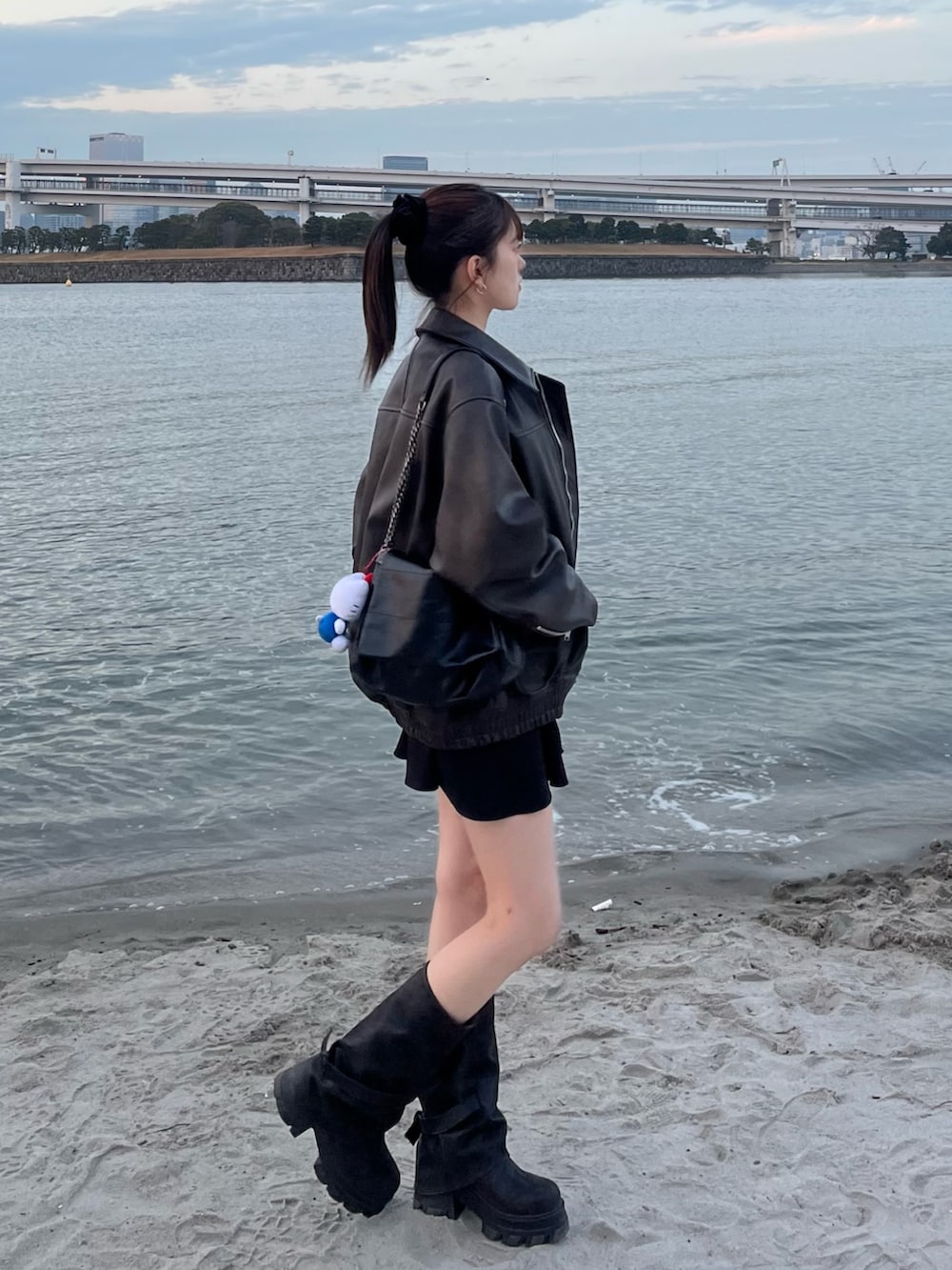 ブラウン系のブルゾン、ホワイト系のシャツ/ブラウス、ブラック系のブーツを着用したレディースの春コーディネートの2枚目の写真