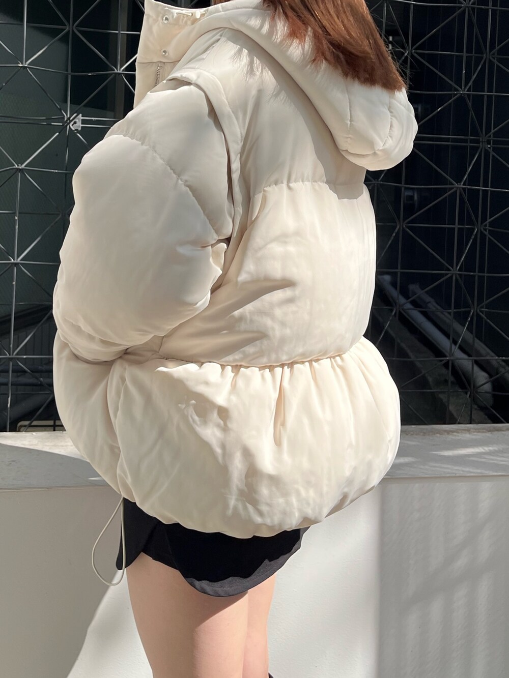 グレー系のスウェット、ホワイト系のブルゾン、ブラック系のスカートを着用したレディースの秋コーディネートの5枚目の写真