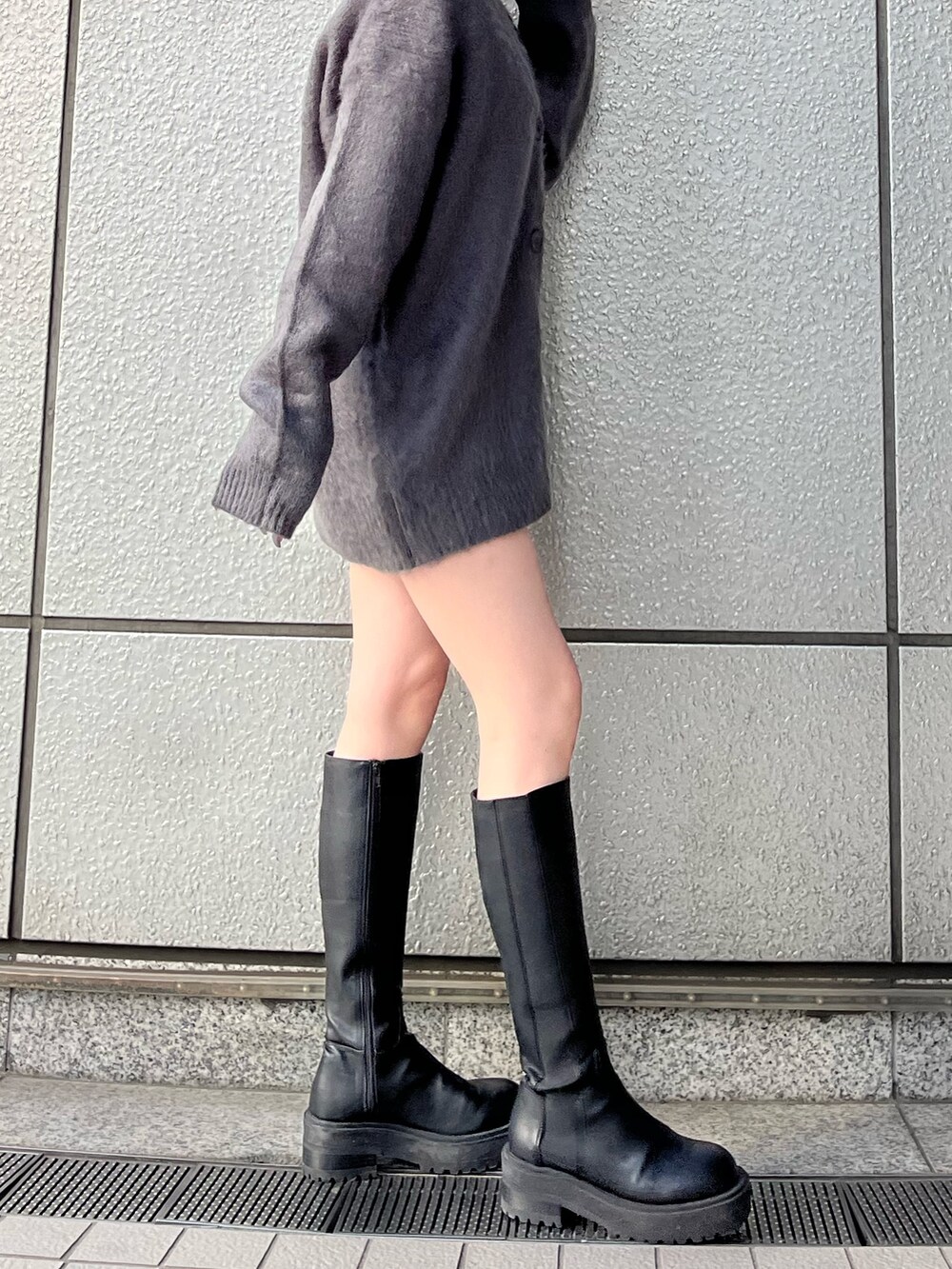 グレー系のカーディガン/ボレロ、グレー系のスカート、ブラック系のブーツを着用したレディースの秋コーディネートの7枚目の写真