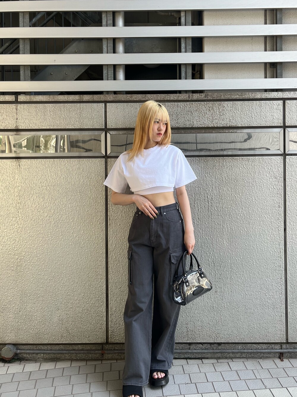 ホワイト系のTシャツ/カットソー、ブラック系のサンダル、ブラック系のデニムパンツを着用したレディースの春コーディネートの2枚目の写真