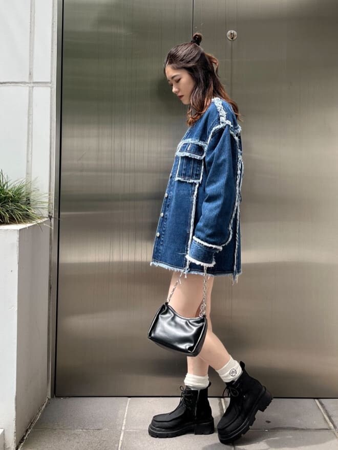 グレー系のスウェット、ブルー系のデニムジャケット、ブラック系のブーツを着用したレディースの秋コーディネートの3枚目の写真