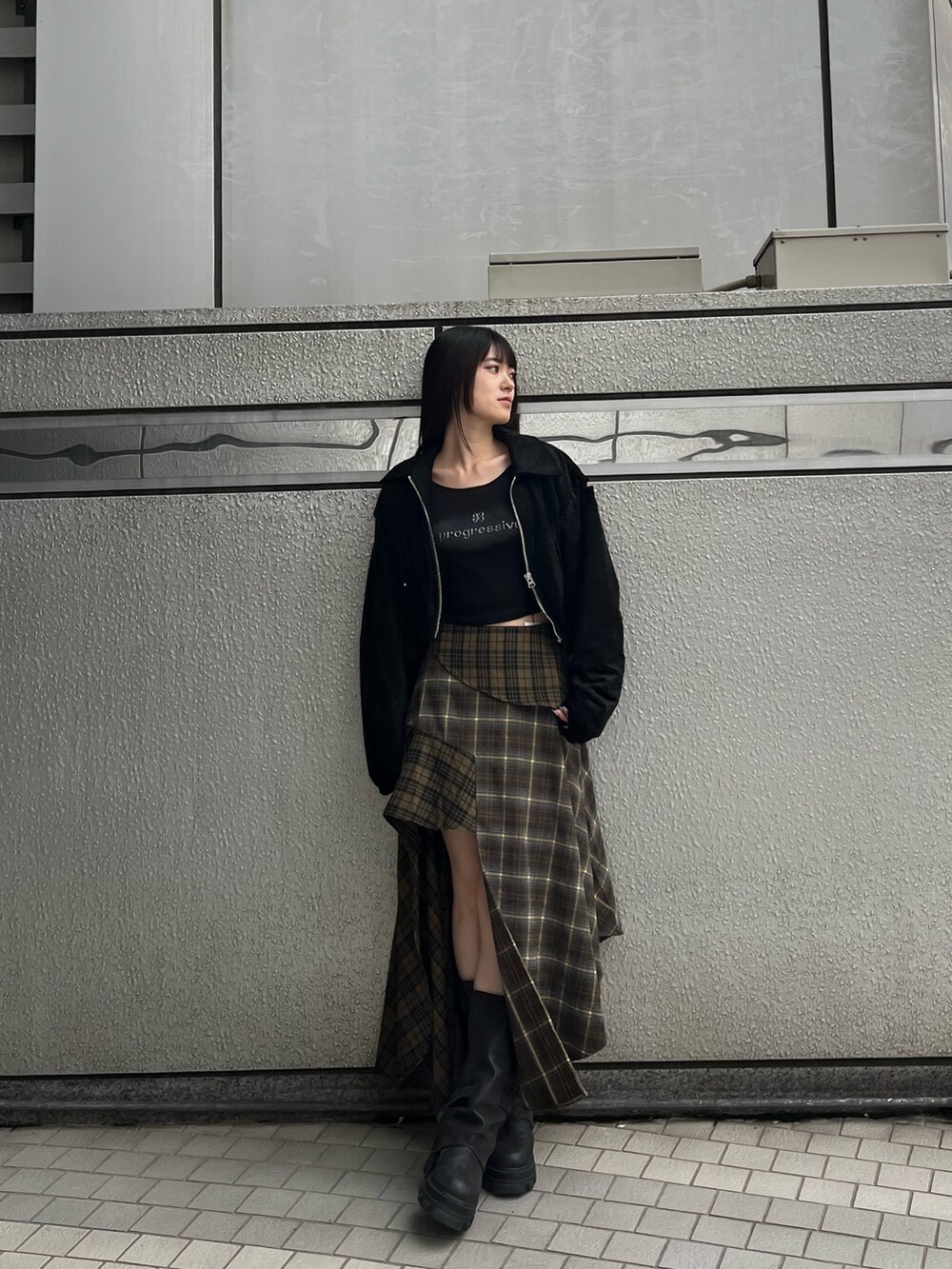 グリーン系のスカート、ブラック系のTシャツ/カットソー、ブラック系のブルゾンを着用したレディースの秋コーディネートの2枚目の写真