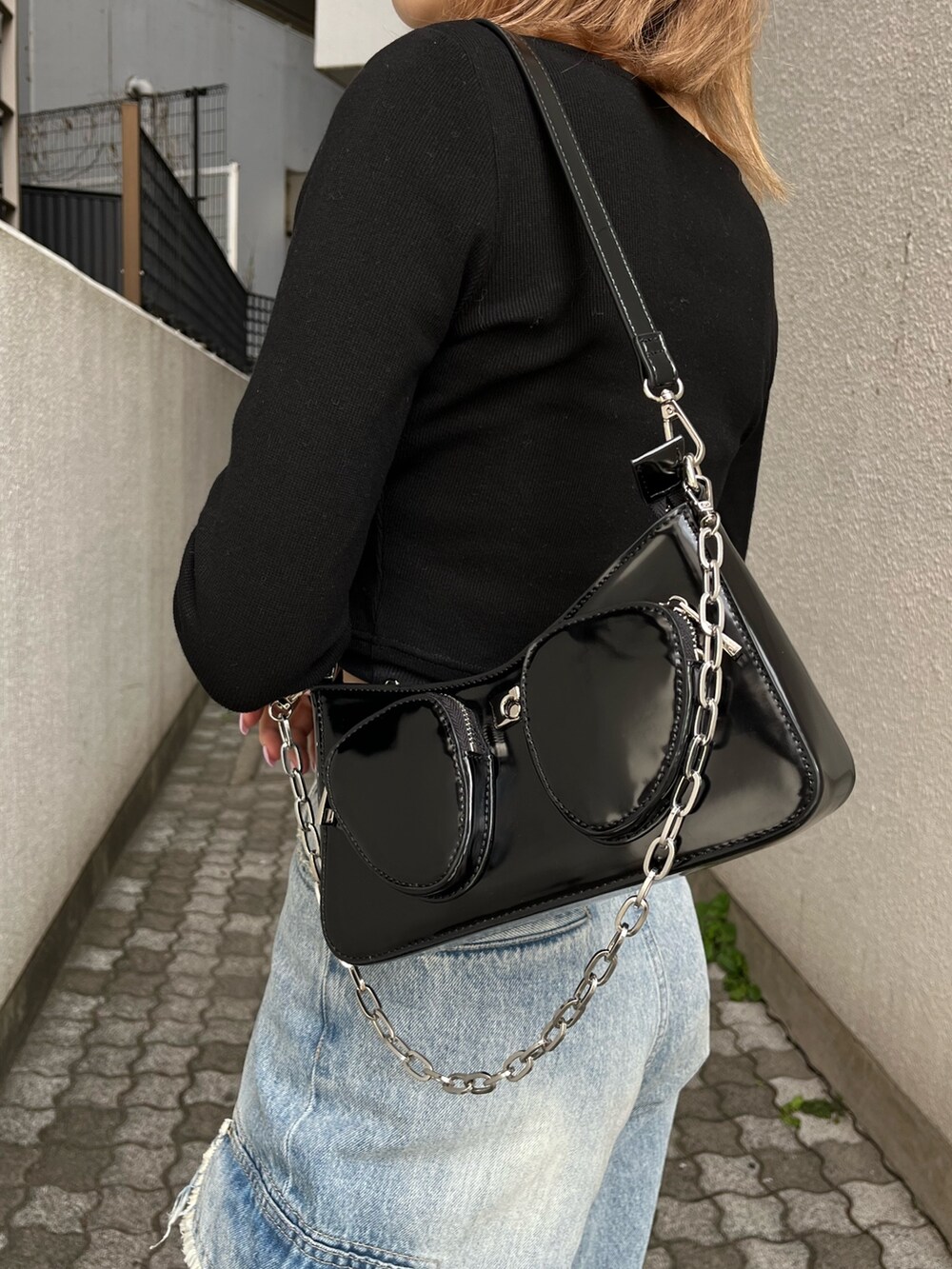 ブラック系のTシャツ/カットソー、ブラック系のスニーカー、ブルー系のデニムパンツを着用したレディースの春コーディネートの7枚目の写真