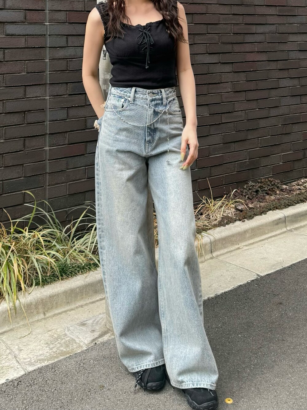 ブルー系のデニムパンツ、ブラウン系のスニーカーを着用したレディースの春コーディネートの4枚目の写真