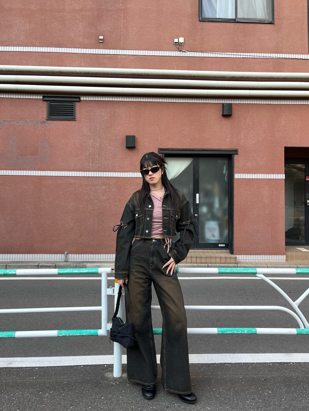 ピンク系のニット/セーター、ブルー系のデニムジャケット、ブルー系のデニムパンツを着用したレディースの冬コーディネートの2枚目の写真