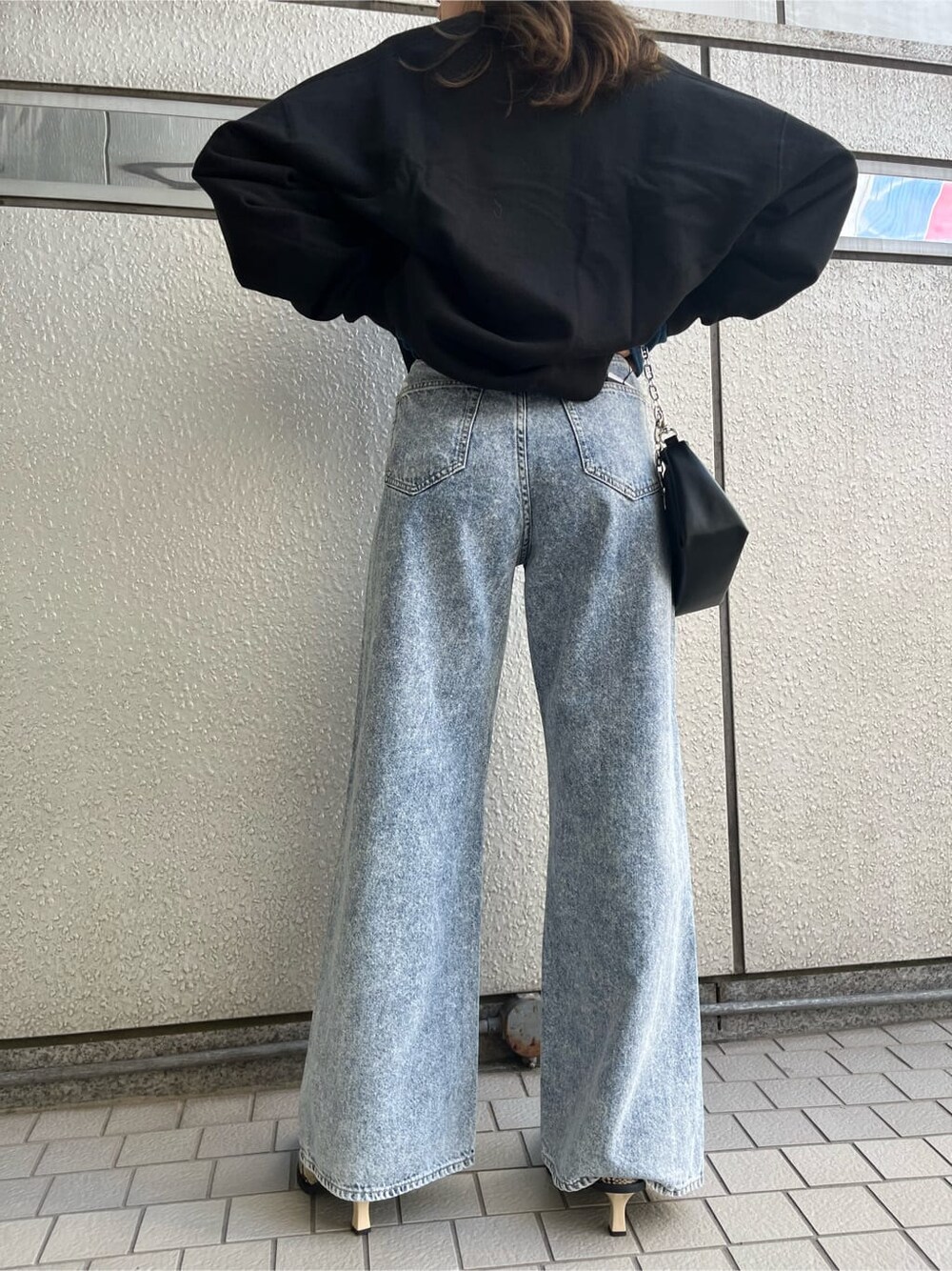 その他のパンプス、ブルー系のデニムパンツ、ブラック系のスウェットを着用したレディースの秋コーディネートの6枚目の写真