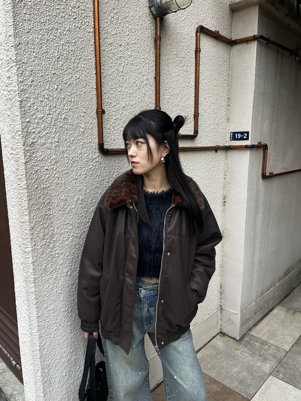 ブルー系のデニムパンツ、ブラック系のブーツ、ブラック系のニット/セーターを着用したレディースの冬コーディネートの3枚目の写真