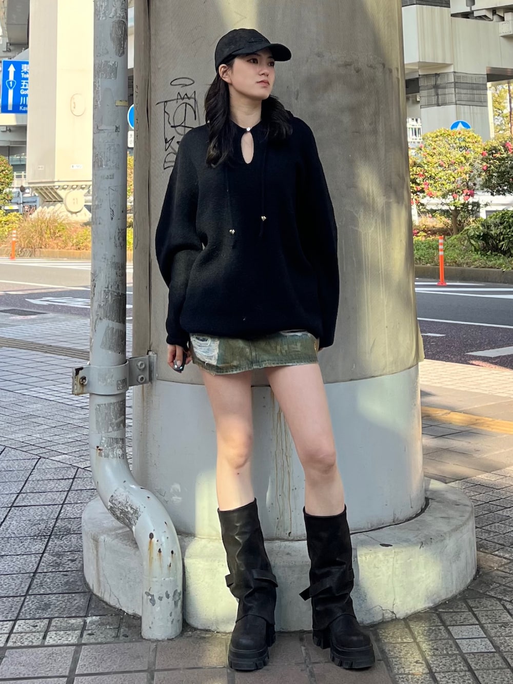 ブラウン系のスカート、ブラック系のブーツ、ブラック系のニット/セーターを着用したレディースの冬コーディネートの2枚目の写真