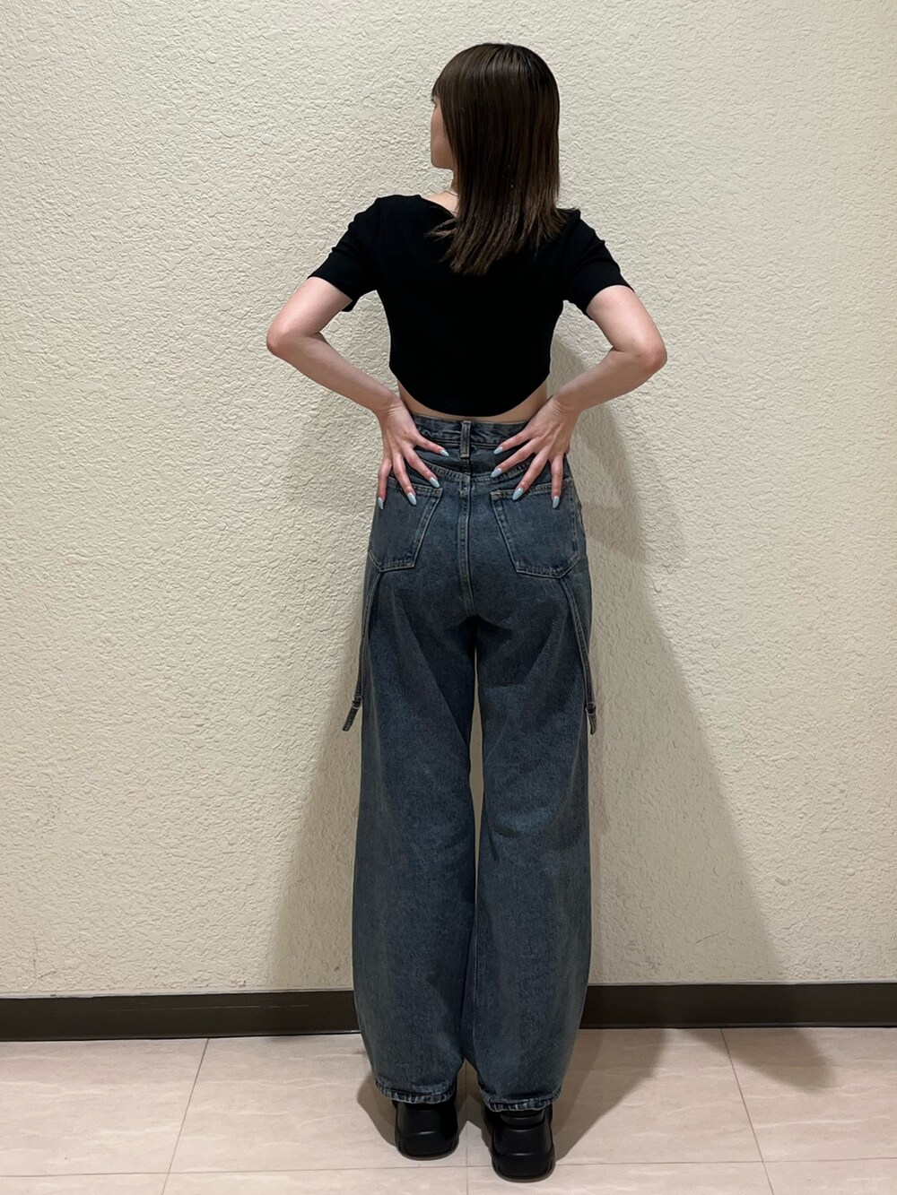 ブルー系のデニムパンツ、ブラック系のTシャツ/カットソー、ブラック系のサンダルを着用したレディースの夏コーディネートの4枚目の写真