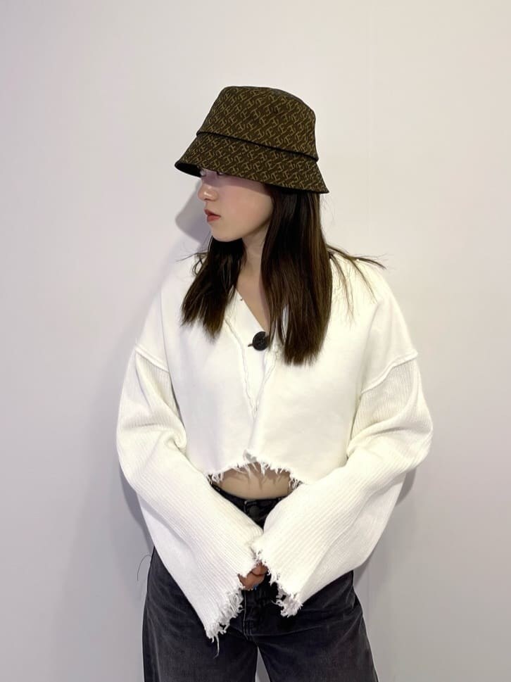 ブラウン系のブーツ、ホワイト系のカーディガン/ボレロ、グレー系のデニムパンツを着用したレディースの秋コーディネートの5枚目の写真