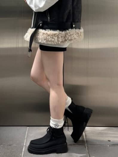 グレー系のスウェット、ブラック系のブーツ、ブラック系のスカートを着用したレディースの秋コーディネートの7枚目の写真