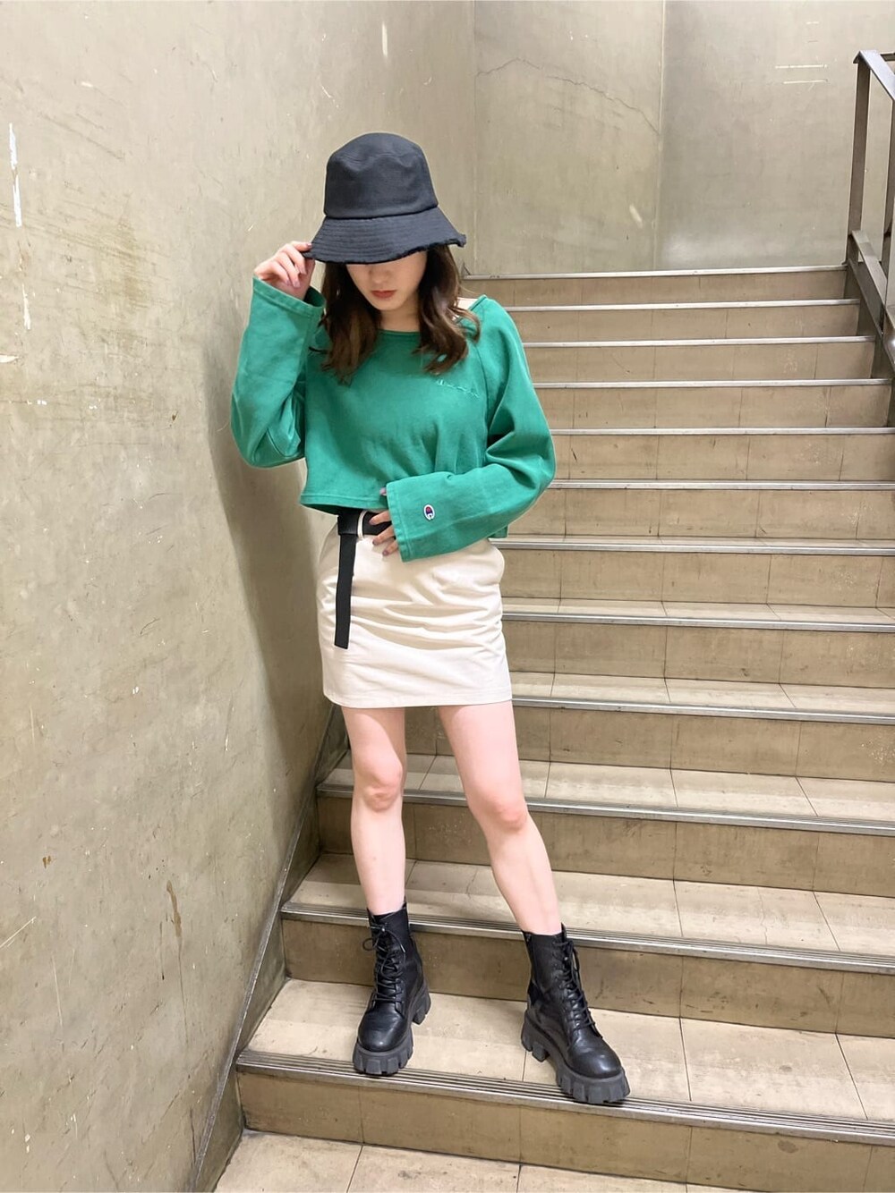 ホワイト系のスカート、ブラック系のハットを着用したレディースの春コーディネートの2枚目の写真