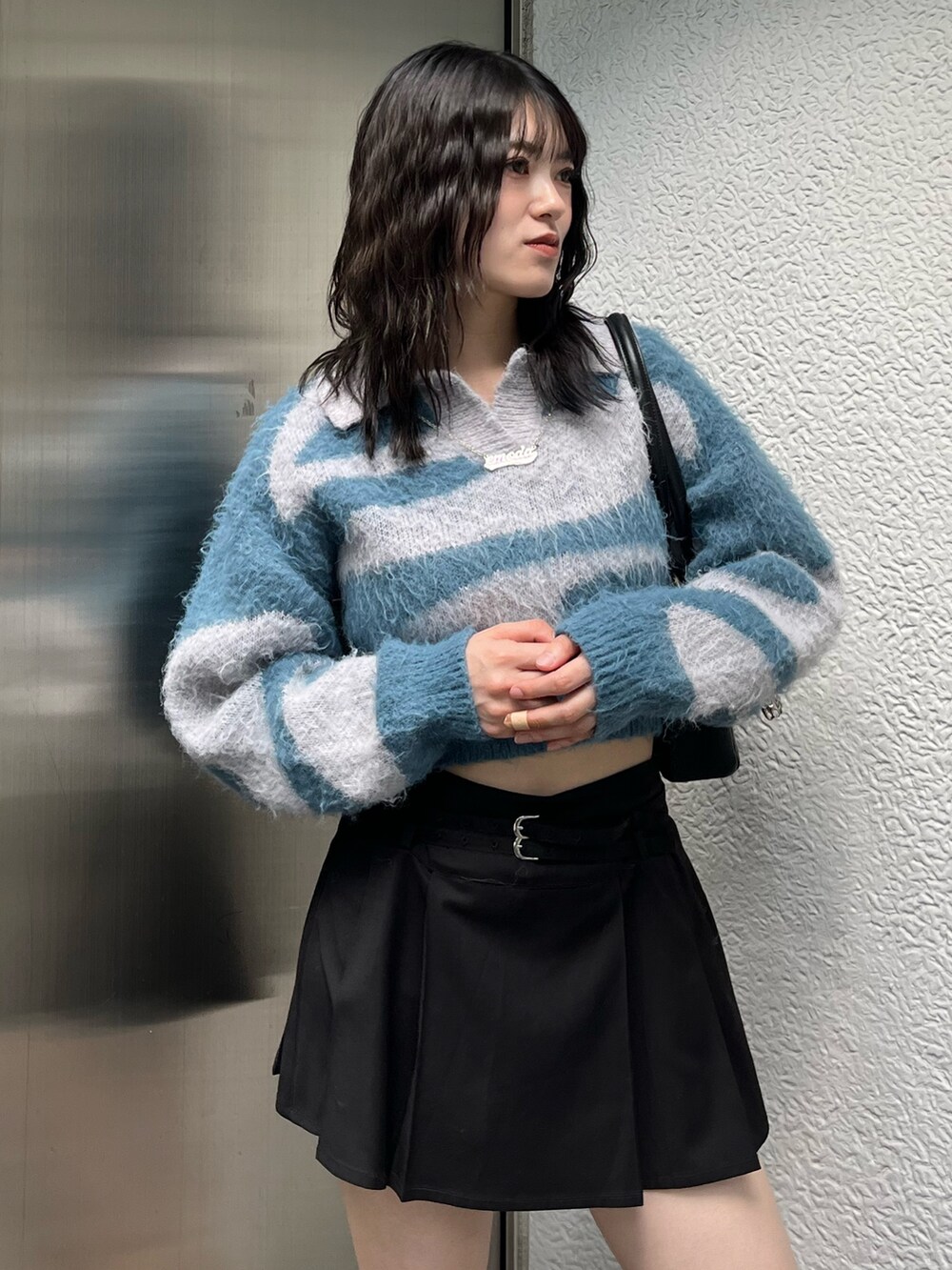 ブラック系のショルダーバッグ、ブラック系のスカート、その他のブーツを着用したレディースの秋コーディネートの5枚目の写真