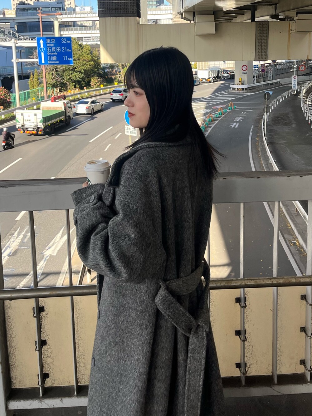 ブラック系のブーツ、ブラック系のニット/セーター、ブルー系のデニムパンツを着用したレディースの冬コーディネートの6枚目の写真