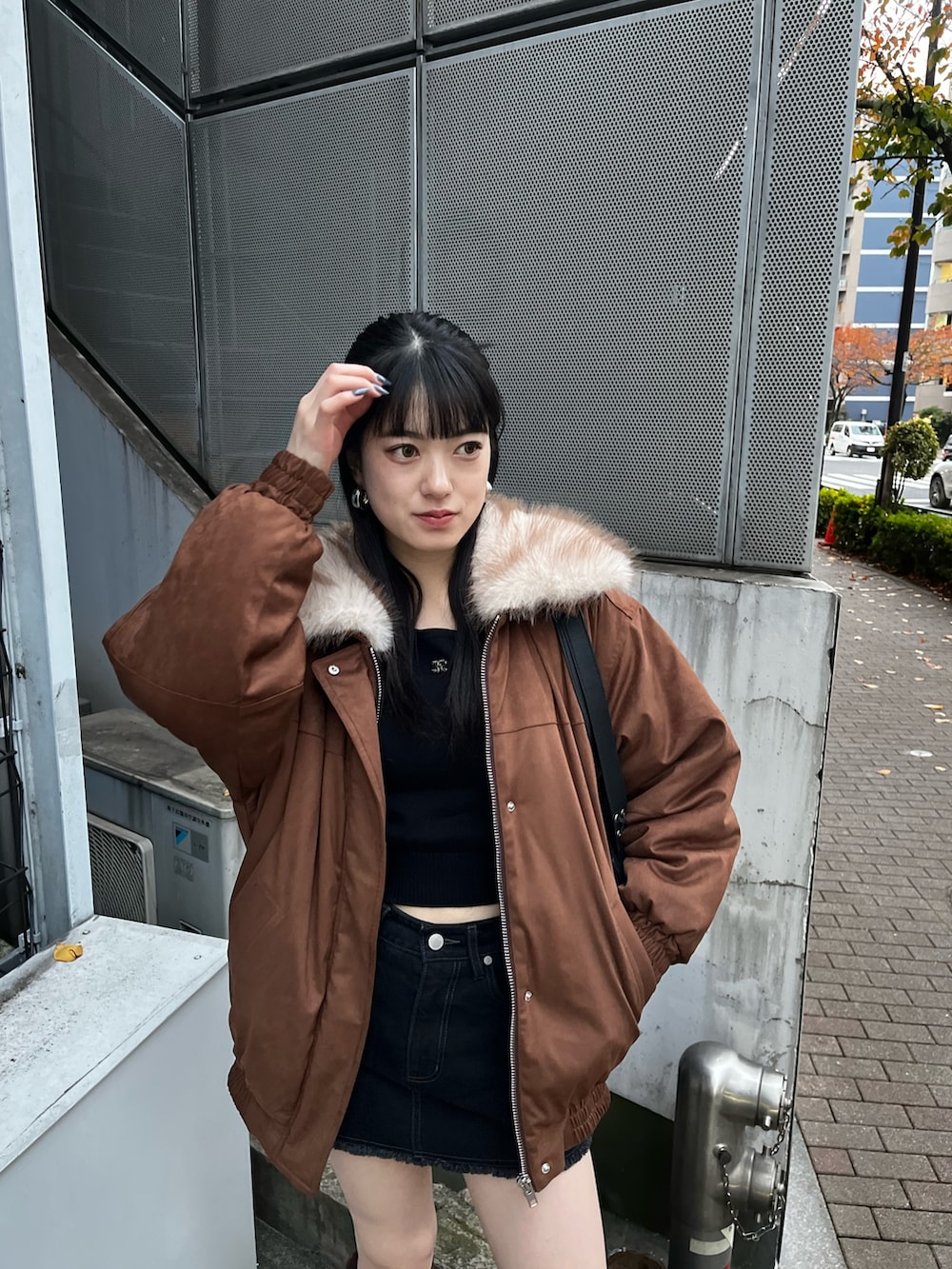 ブラック系のスカート、ブラウン系のブーツ、ブラック系のニット/セーターを着用したレディースの冬コーディネートの3枚目の写真