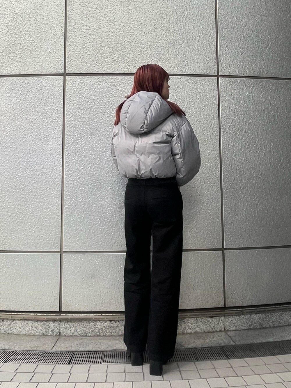 ブラック系のデニムパンツ、ブルー系のニット/セーター、グレー系のダウンジャケット/コートを着用したレディースの冬コーディネートの3枚目の写真