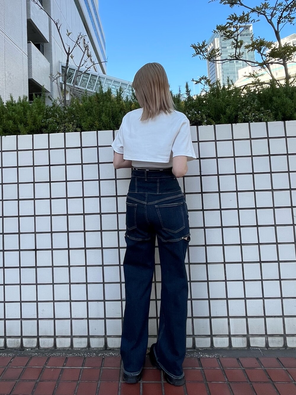 ブラック系のスニーカー、ブルー系のデニムパンツ、ホワイト系のTシャツ/カットソーを着用したレディースの春コーディネートの3枚目の写真