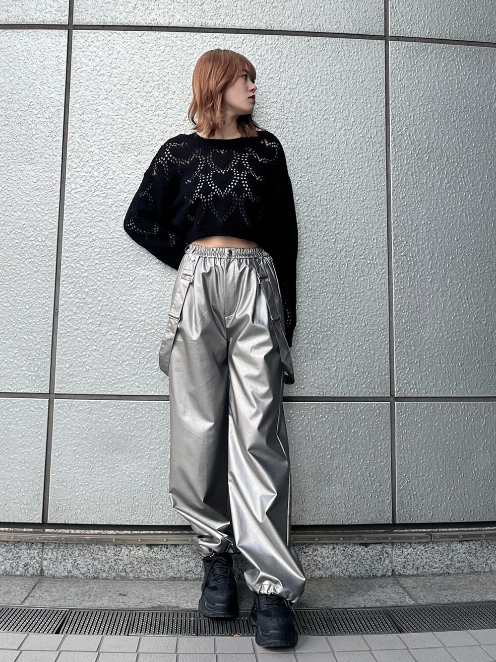 ブラック系のスニーカー、ブラック系のニット/セーター、ホワイト系のキャミソールを着用したレディースの冬コーディネートの2枚目の写真