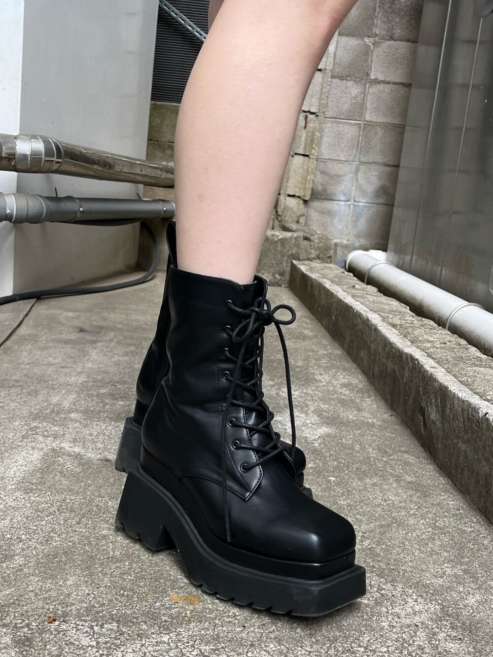 ブラック系のブーツ、ブラック系のスカート、その他のTシャツ/カットソーを着用したレディースの冬コーディネートの7枚目の写真