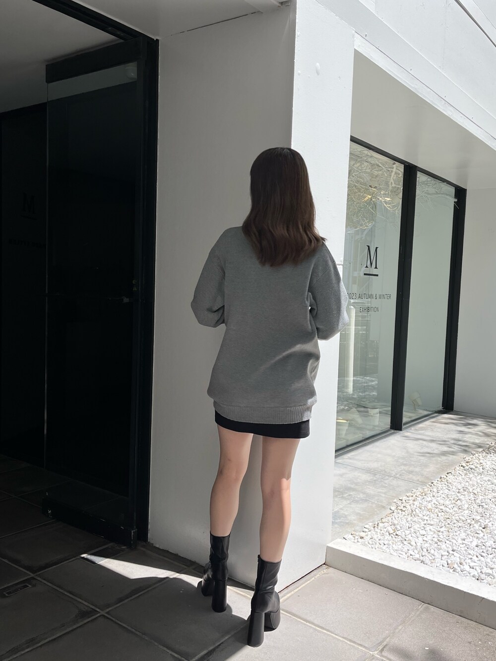 グレー系のカーディガン/ボレロ、ブラック系のスカート、ブラック系のブーツを着用したレディースの夏コーディネートの5枚目の写真