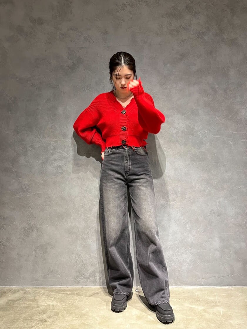 ブラック系のブーツ、グレー系のデニムパンツ、レッド系のカーディガン/ボレロを着用したレディースの秋コーディネートの2枚目の写真