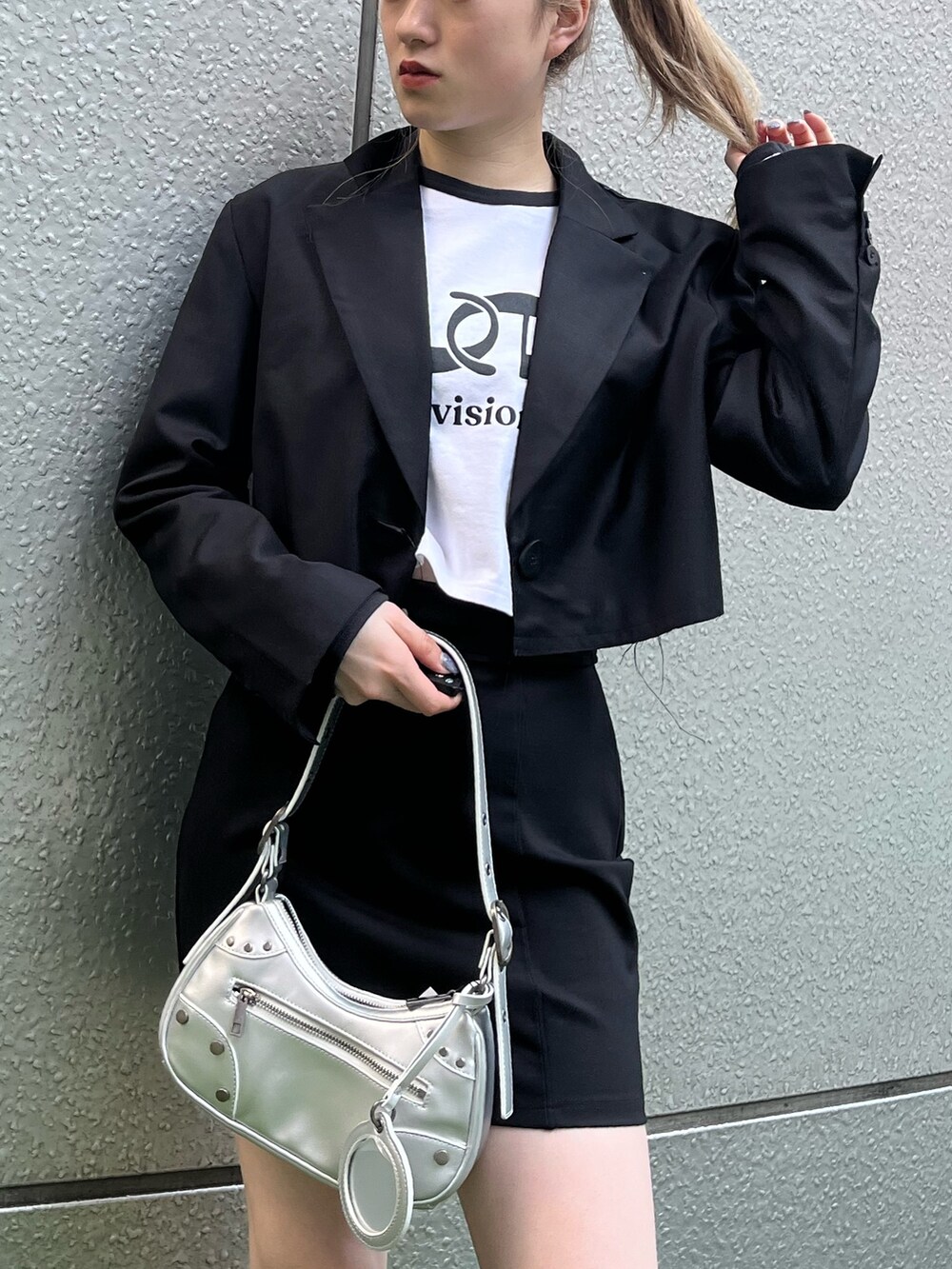 ブラック系のブーツ、シルバー系のハンドバッグ、ブラック系のテーラードジャケットを着用したレディースの春コーディネートの5枚目の写真