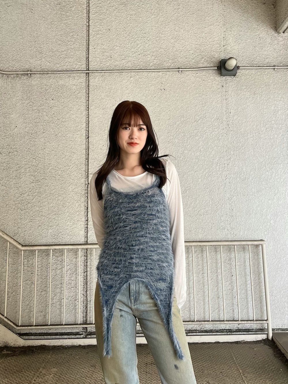 ブルー系のニット/セーター、ホワイト系のTシャツ/カットソー、ブルー系のデニムパンツを着用したレディースの春コーディネートの4枚目の写真