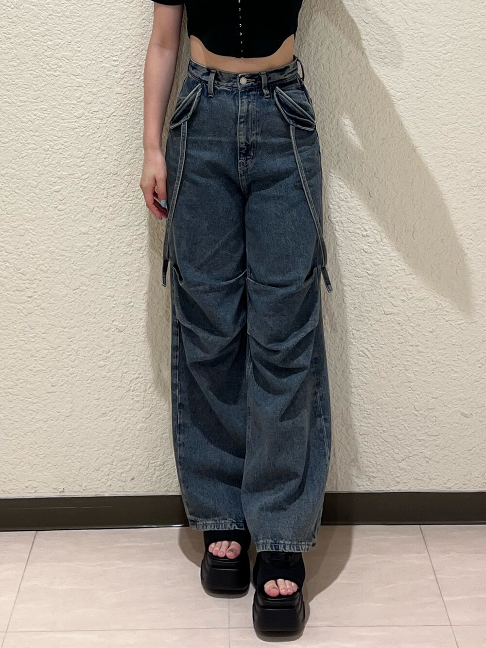 ブルー系のデニムパンツ、ブラック系のTシャツ/カットソー、ブラック系のサンダルを着用したレディースの夏コーディネートの6枚目の写真