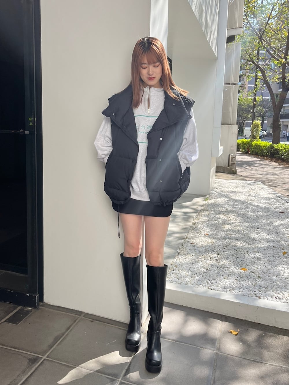 ブラック系のブーツ、グレー系のスウェット、ブラック系のスカートを着用したレディースの秋コーディネートの2枚目の写真