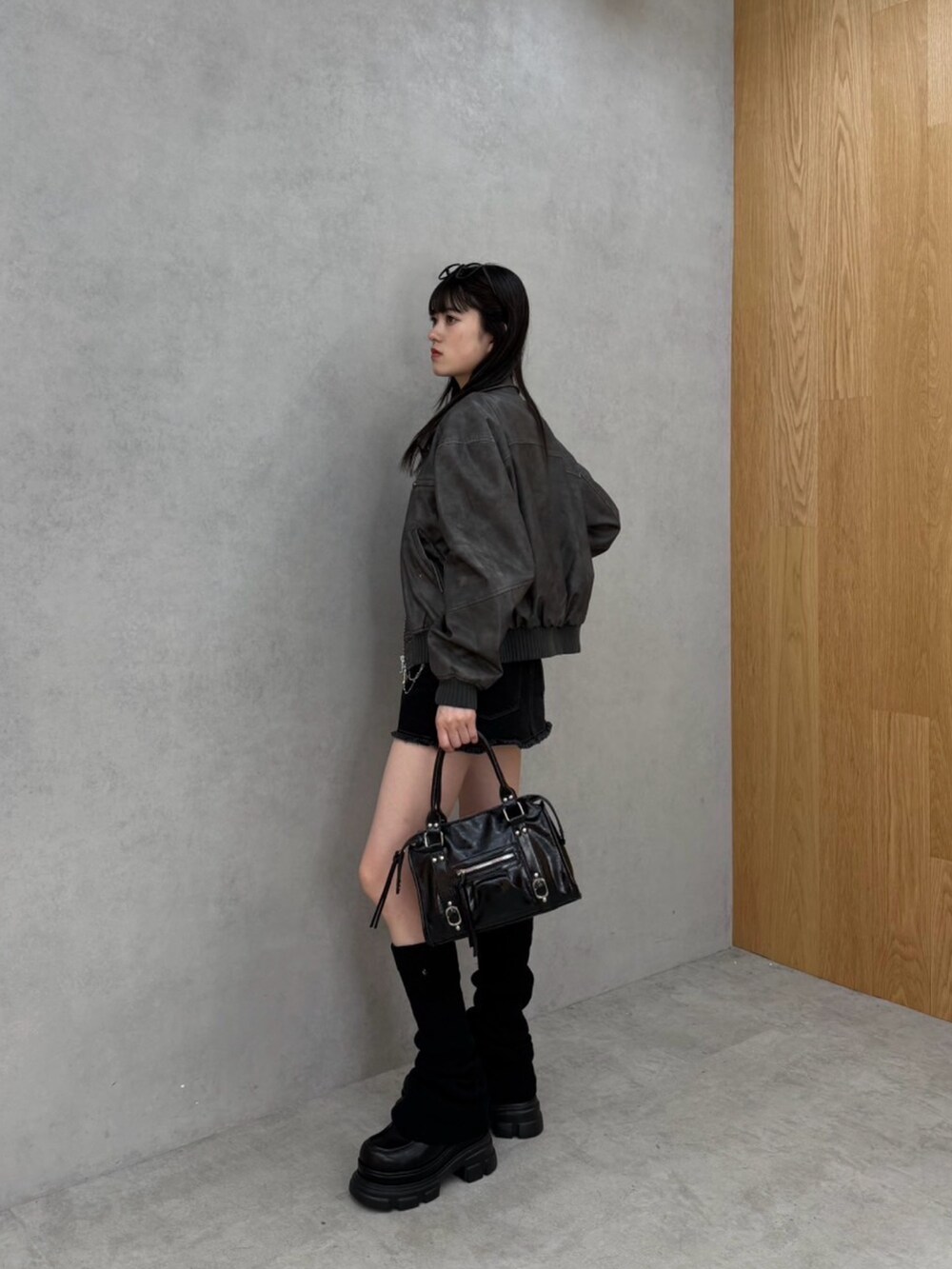 ブラック系のスカート、グレー系のTシャツ/カットソー、グレー系のブルゾンを着用したレディースの秋コーディネートの2枚目の写真