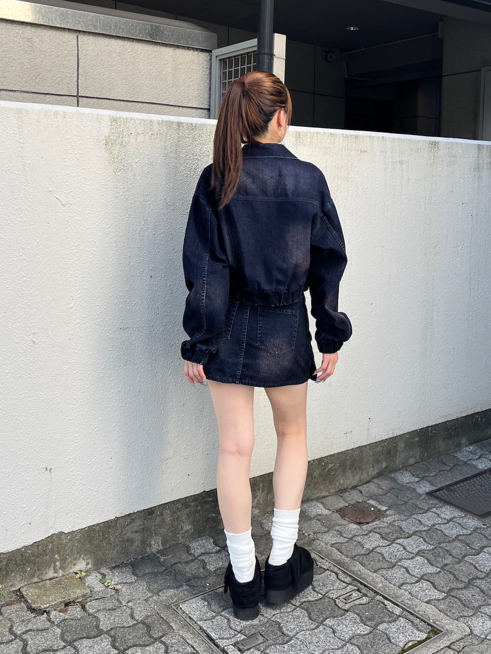 ブラック系のスリッポン、ブルー系のブルゾン、ブルー系のスカートを着用したレディースの夏コーディネートの3枚目の写真