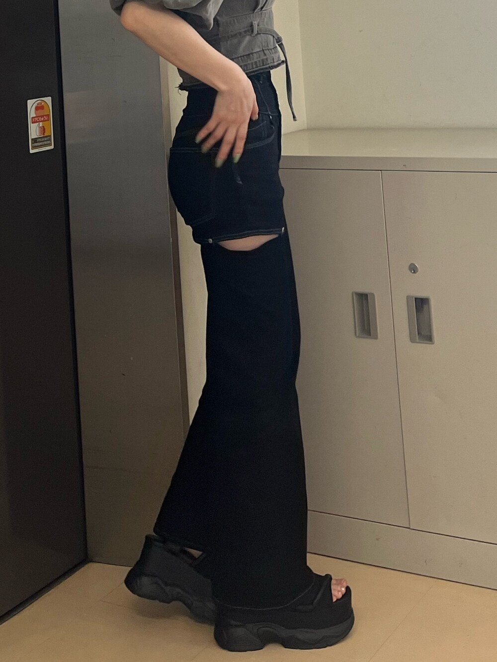 ブラック系のデニムパンツ、ブラック系のサンダル、グレー系のシャツ/ブラウスを着用したレディースの春コーディネートの7枚目の写真