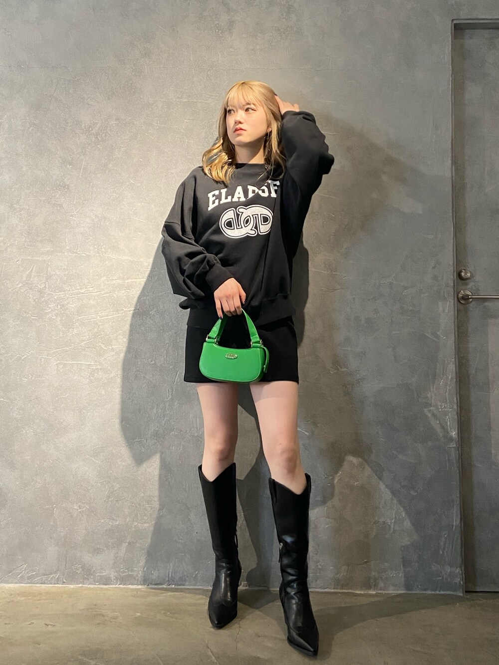 ブラック系のTシャツ/カットソー、ブラック系のブーツ、ブラック系のスカートを着用したレディースの冬コーディネートの2枚目の写真