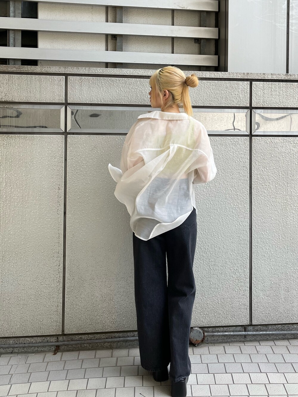 ブラック系のデニムパンツ、ブラック系のサンダル、イエロー系のタンクトップを着用したレディースの春コーディネートの4枚目の写真