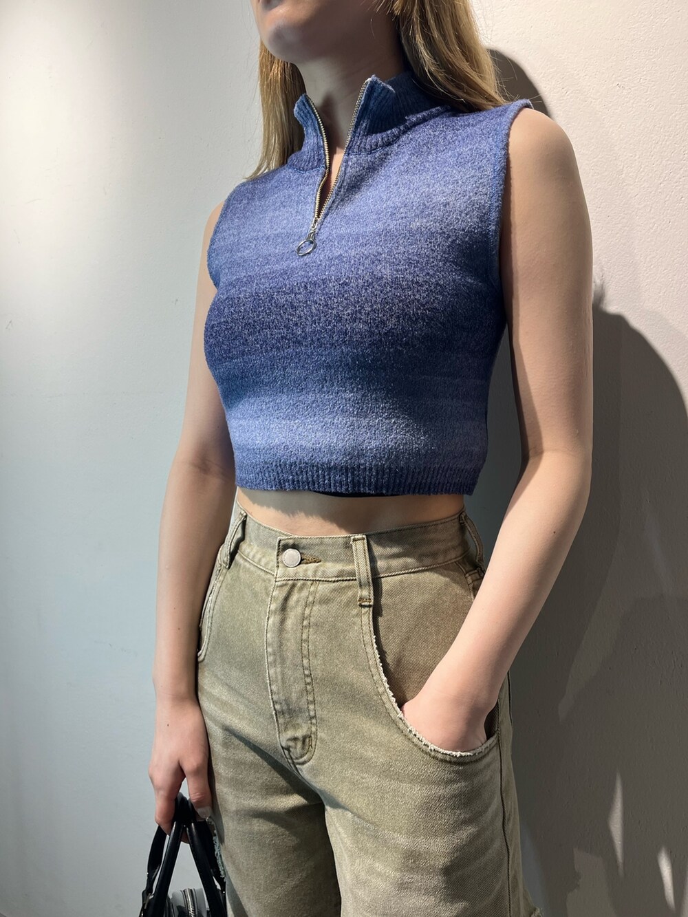 ベージュ系のデニムパンツ、その他のハンドバッグ、ブルー系のタンクトップを着用したレディースの春コーディネートの7枚目の写真