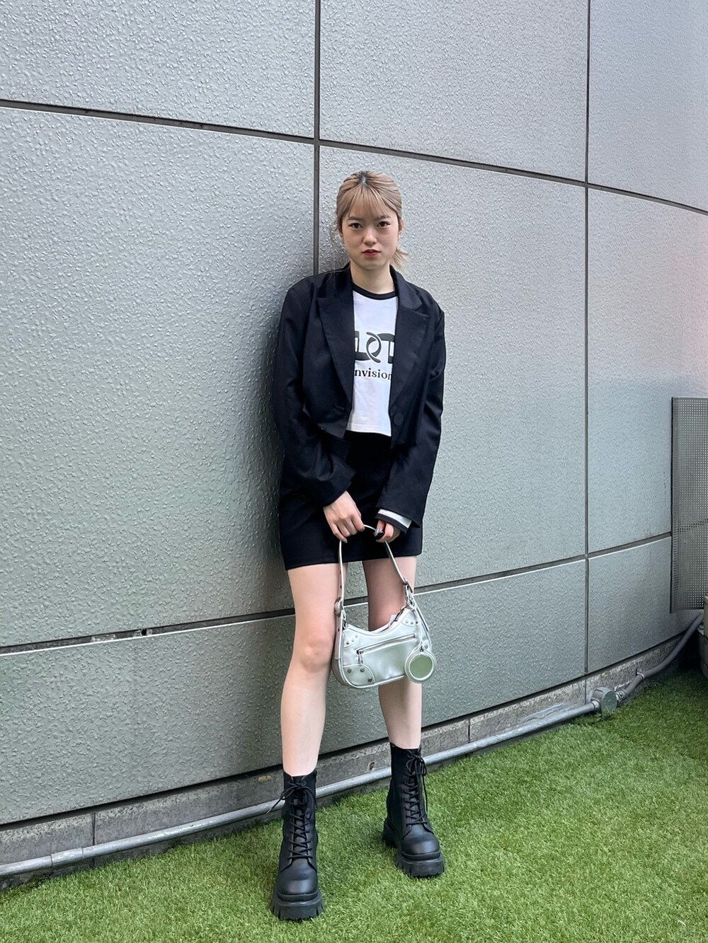 ブラック系のブーツ、シルバー系のハンドバッグ、ブラック系のテーラードジャケットを着用したレディースの春コーディネートの7枚目の写真