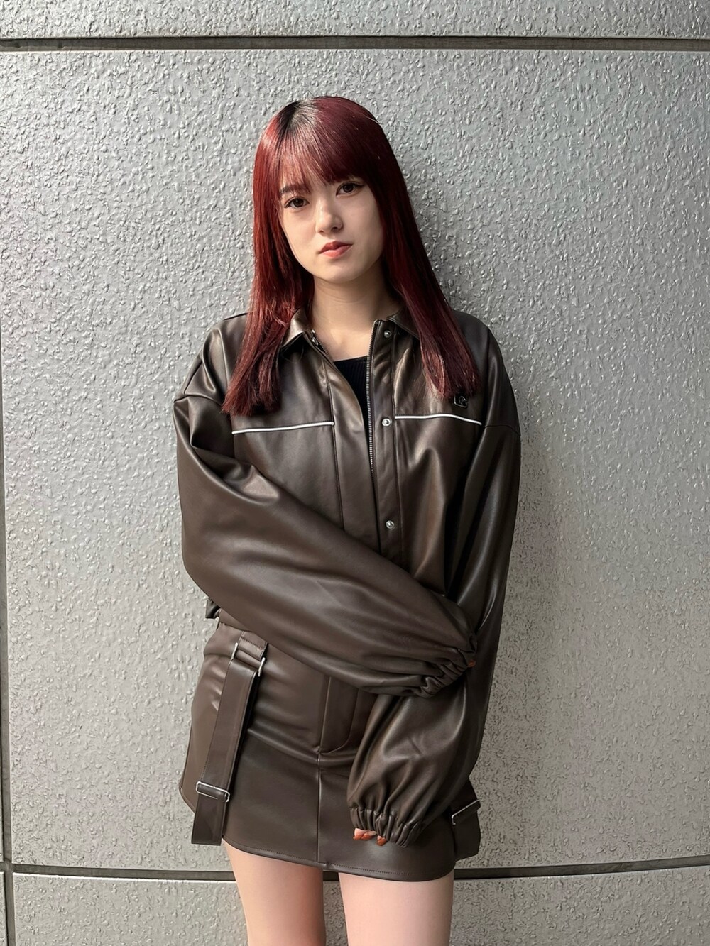 ブラウン系のスカート、ブラック系のニット/セーター、ブラウン系のブルゾンを着用したレディースの冬コーディネートの6枚目の写真