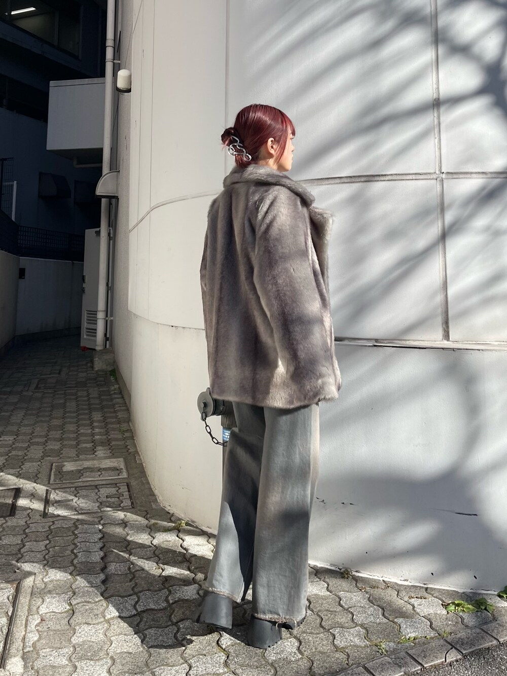 グレー系のその他アウター、グレー系のデニムパンツ、ブラック系のニット/セーターを着用したレディースの冬コーディネートの4枚目の写真