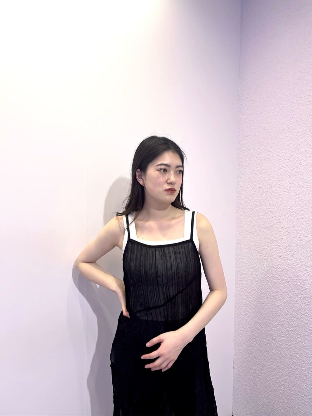 ホワイト系のタンクトップ、ブラック系のワンピース、ブルー系のデニムパンツを着用したレディースの夏コーディネートの5枚目の写真