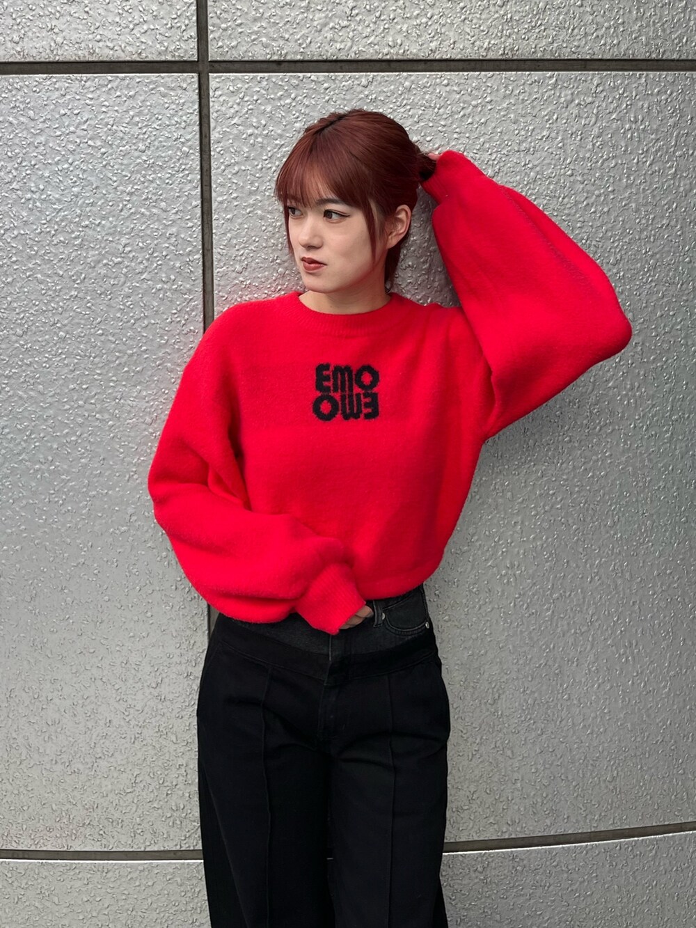 レッド系のニット/セーター、ブラック系のデニムパンツ、ブラック系のブーツを着用したレディースの冬コーディネートの6枚目の写真