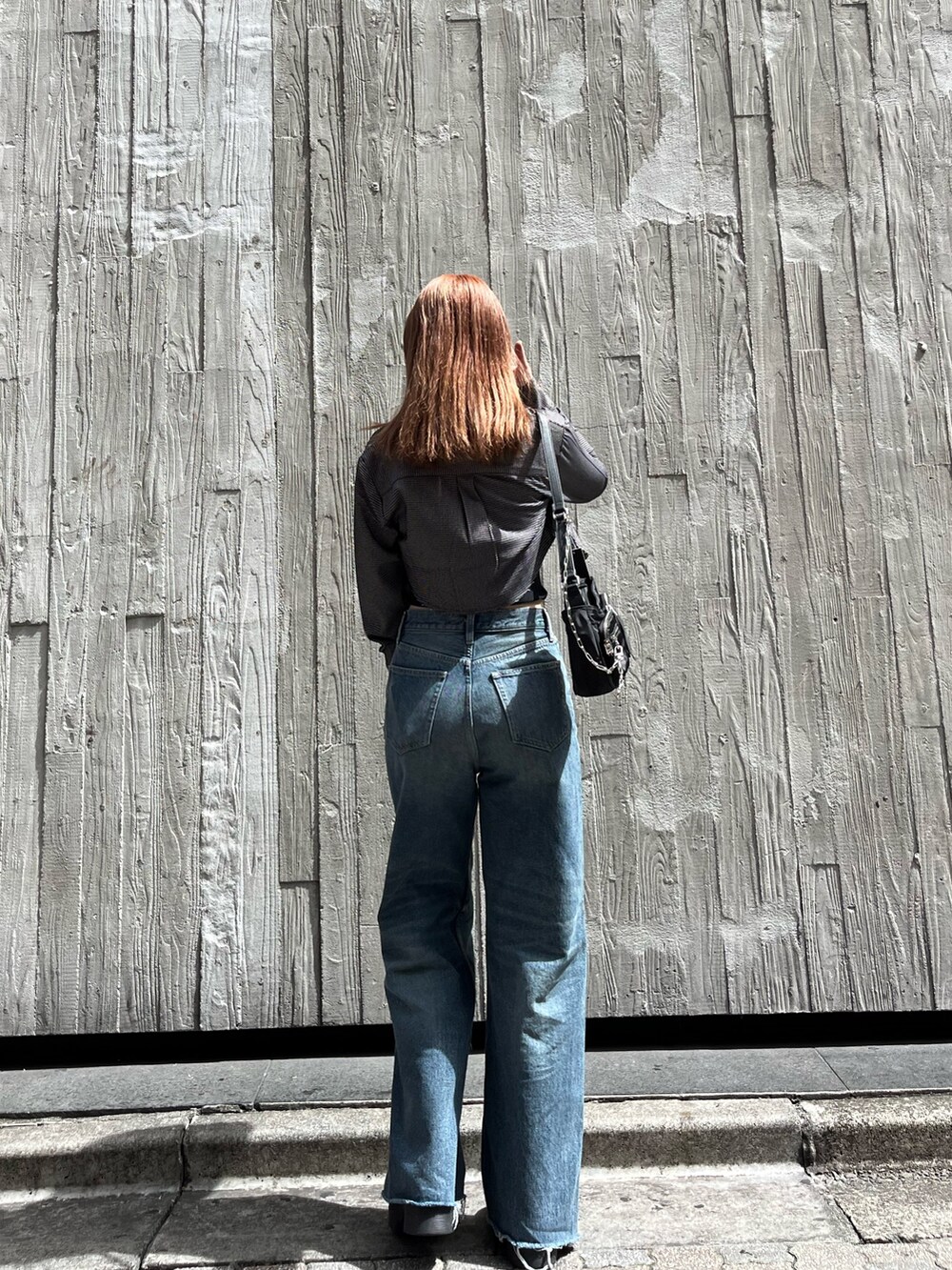 ブラック系のブーツ、ブラック系のキャミソール、ブルー系のデニムパンツを着用したレディースの夏コーディネートの3枚目の写真