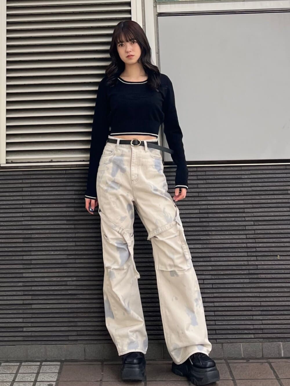 ブラック系のスニーカー、ホワイト系のデニムパンツ、ブラック系のニット/セーターを着用したレディースの冬コーディネートの2枚目の写真