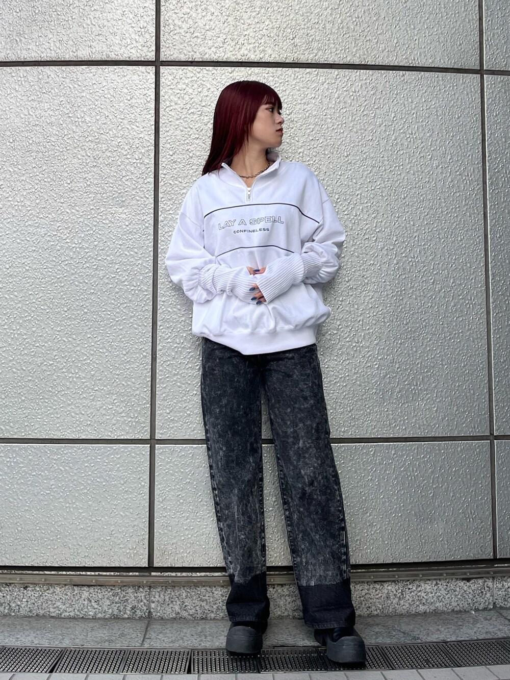 ホワイト系のスウェット、ブラック系のデニムパンツ、ブラック系のブーツを着用したレディースの秋コーディネートの2枚目の写真