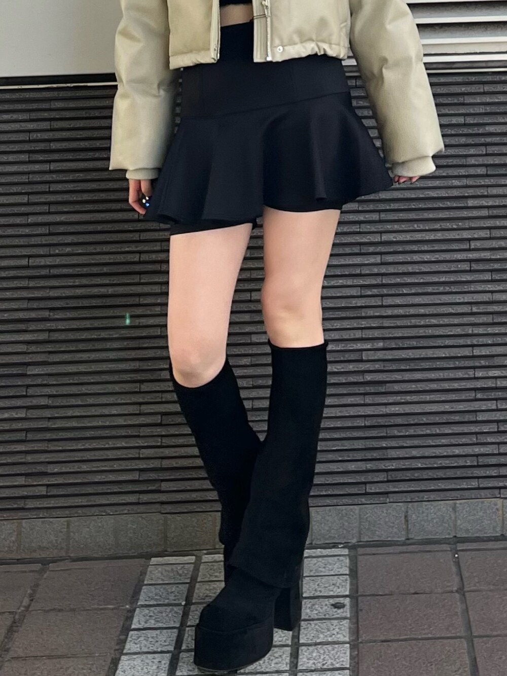 ブラック系のスカート、ブラック系のブーツ、ブラック系のニット/セーターを着用したレディースの冬コーディネートの5枚目の写真