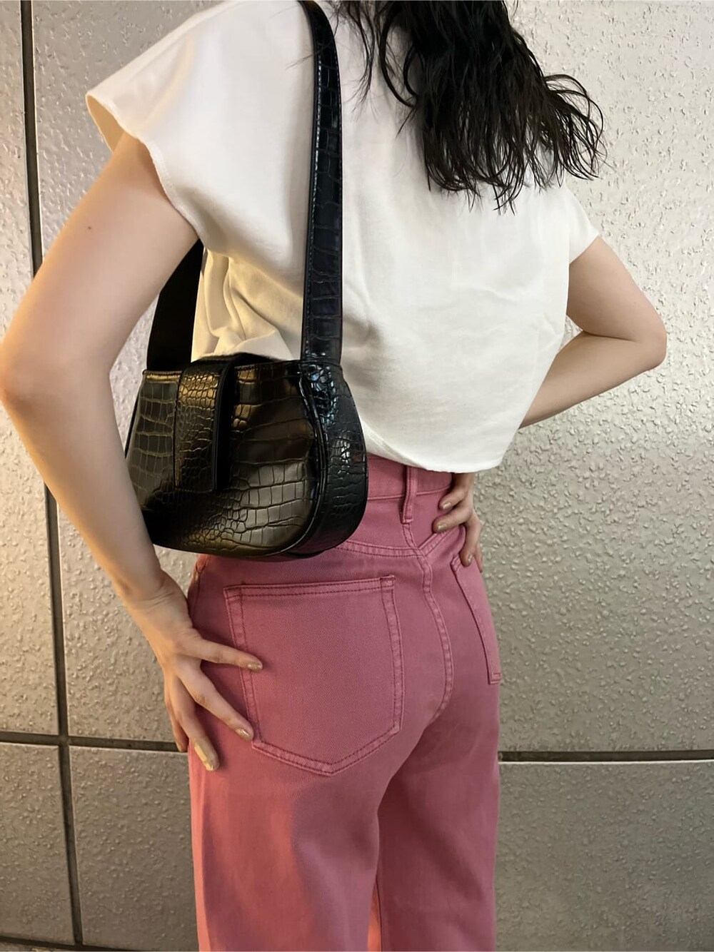 ピンク系のデニムパンツ、ブラック系のサンダル、ブラック系のハンドバッグを着用したレディースの夏コーディネートの8枚目の写真