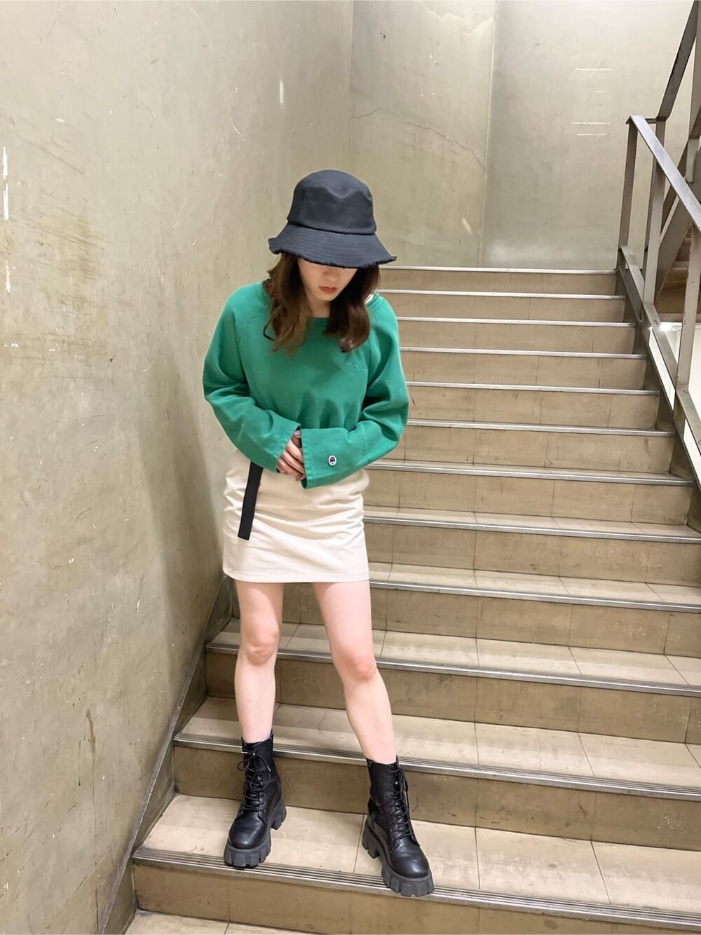 ホワイト系のスカート、ブラック系のハットを着用したレディースの春コーディネートの3枚目の写真