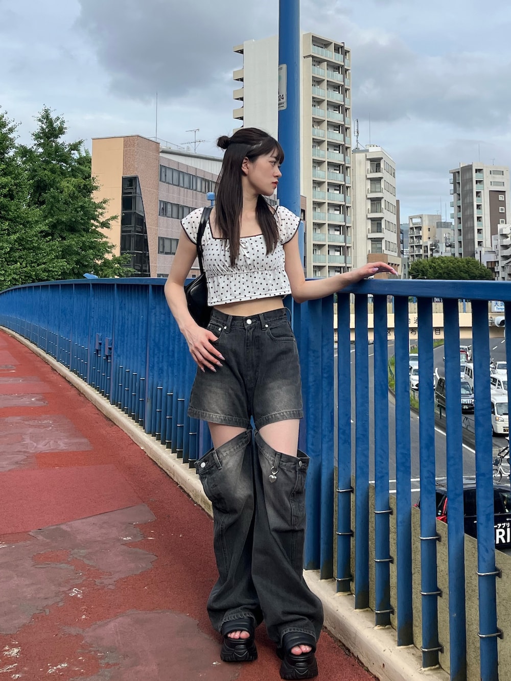 ホワイト系のタンクトップ、ブラック系のデニムパンツ、ブラック系のサンダルを着用したレディースの夏コーディネートの2枚目の写真