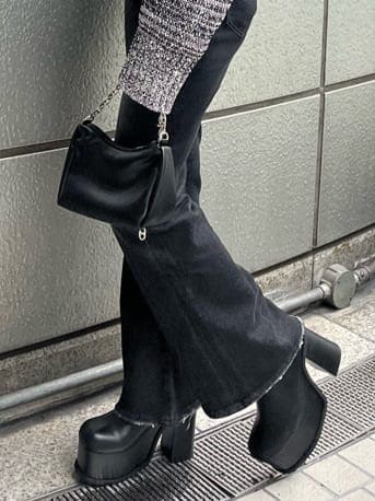 ブラック系のブーツ、ブラック系のデニムパンツ、その他のニット/セーターを着用したレディースの秋コーディネートの6枚目の写真
