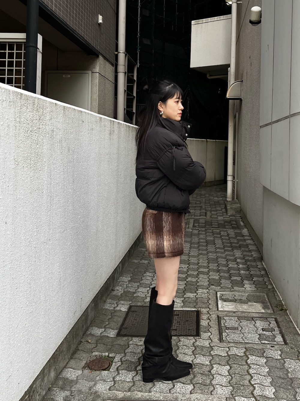 ブラウン系のその他パンツ、ブラック系のブーツ、ブラック系のダウンジャケット/コートを着用したレディースの冬コーディネートの2枚目の写真
