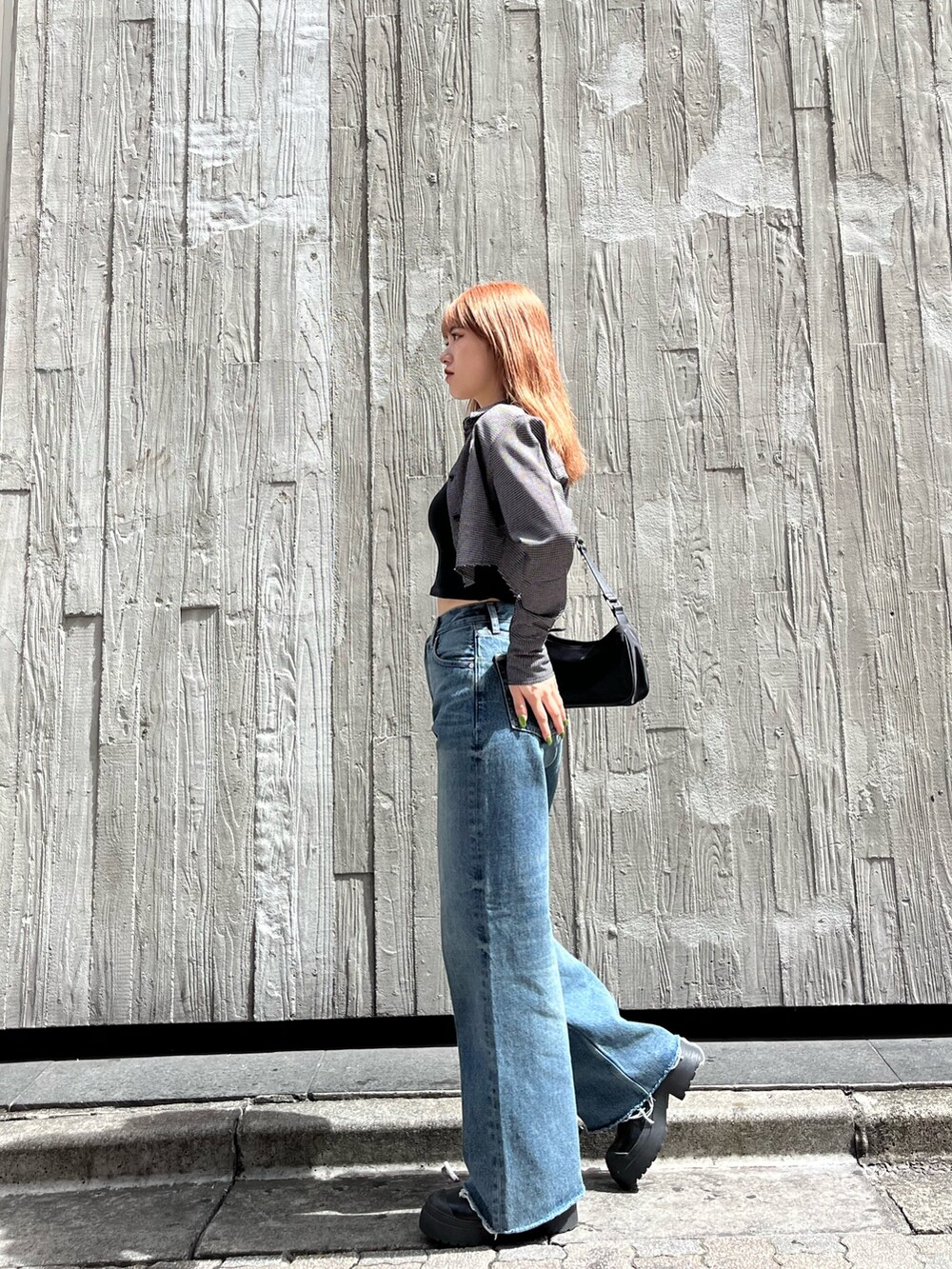 ブラック系のブーツ、ブラック系のキャミソール、ブルー系のデニムパンツを着用したレディースの夏コーディネートの2枚目の写真